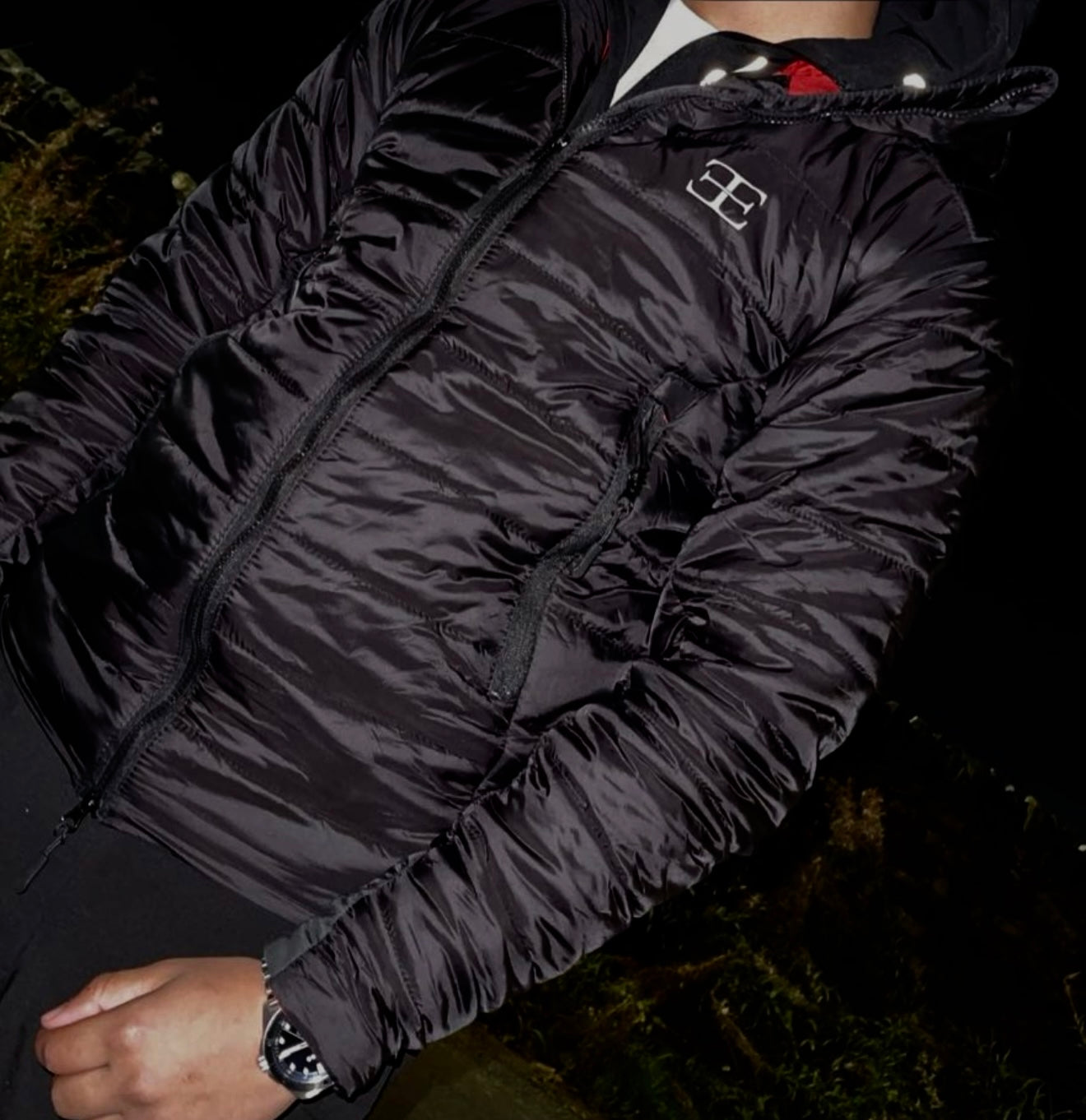 man wearing black puffer jacket with Elegante clothing logo on chest