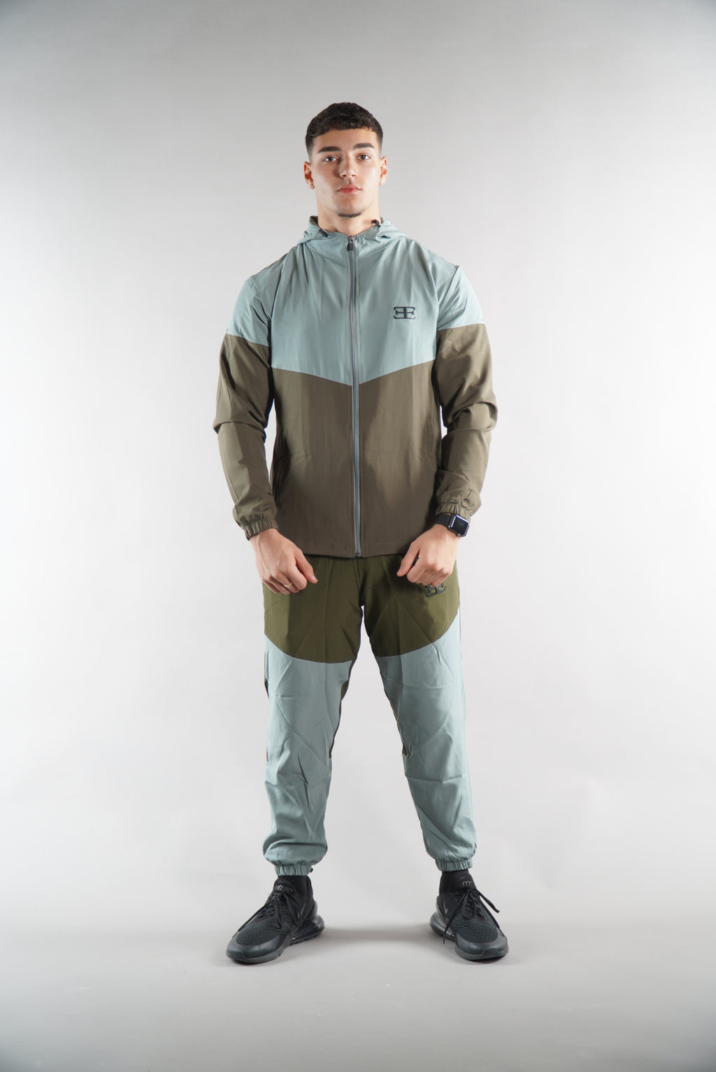 Man wearing Olive Green tracksuit Jacket and tracksuit pants set, sports clothing for men, white background