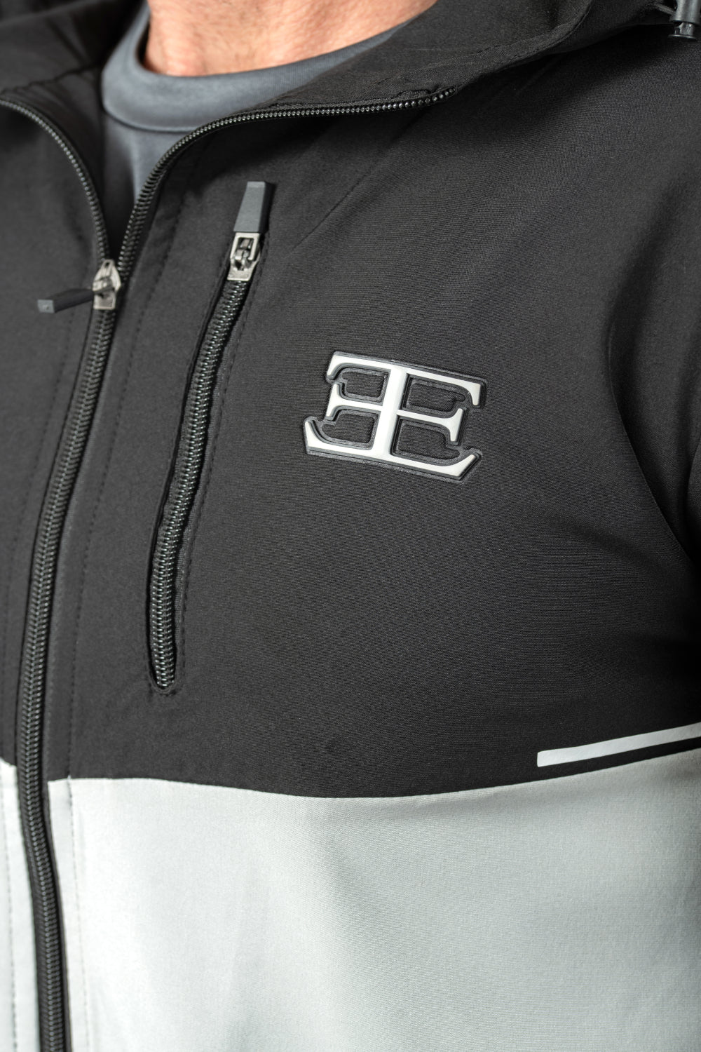 Close-up of a black and gray jacket with a logo on the chest.