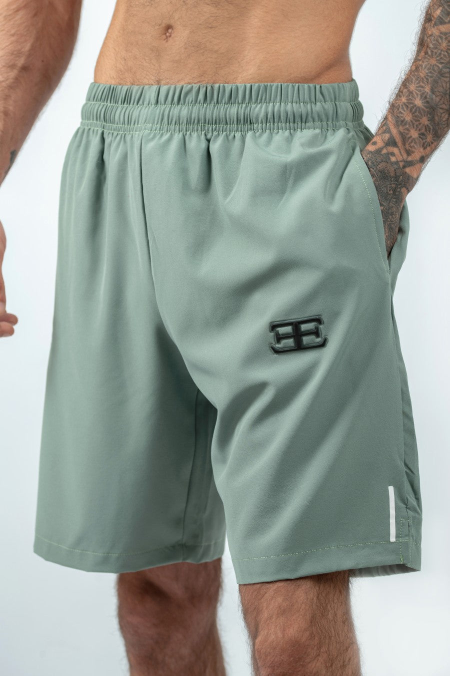 man wearing Green athletic shorts with a logo on a white background