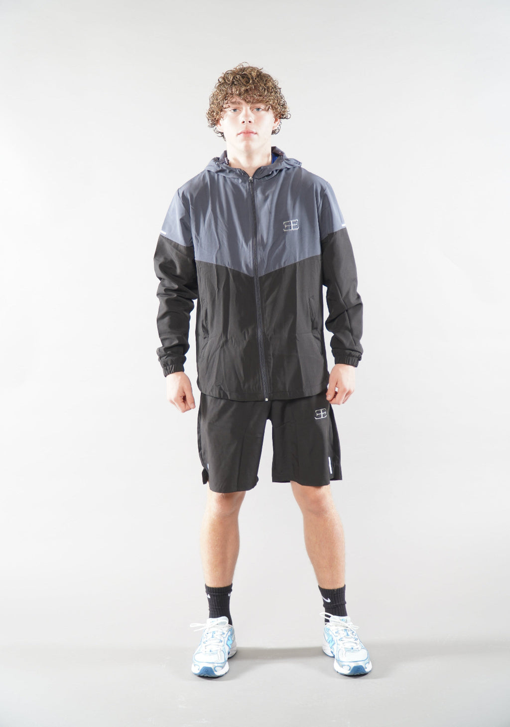 man wearing Elegante Black Gym Shorts, and tracksuit jacket activewear for men, 