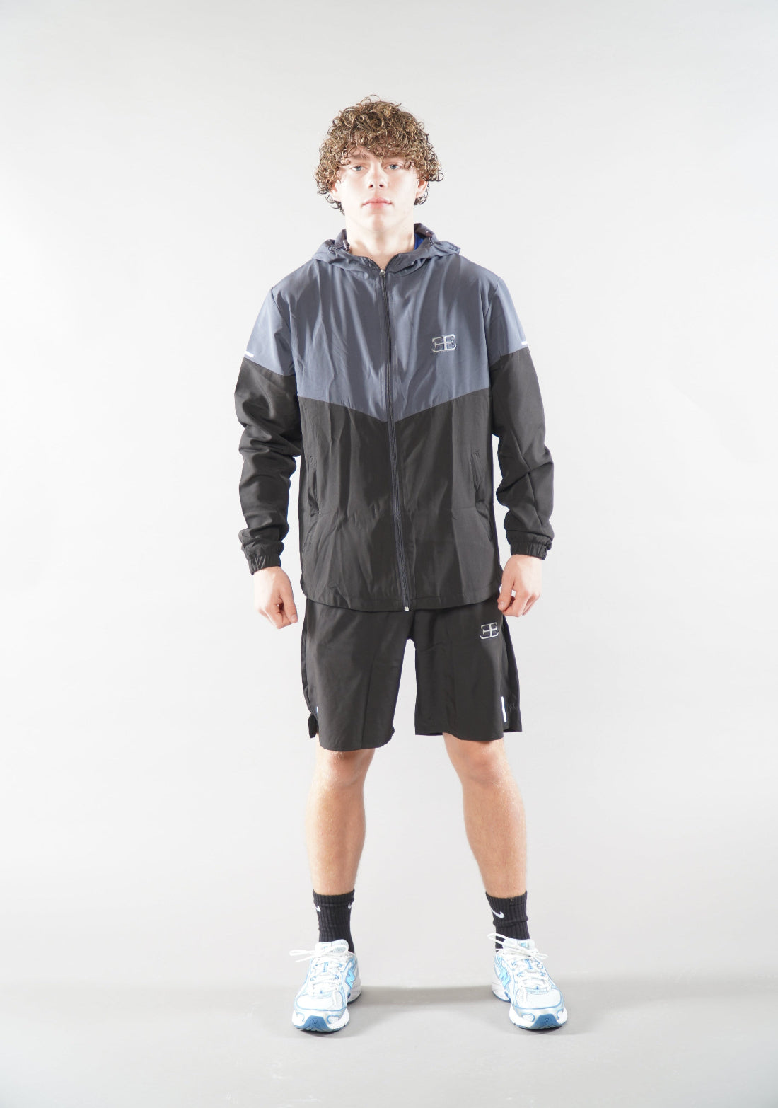 man wearing Elegante Black Gym Shorts, and tracksuit jacket activewear for men, 