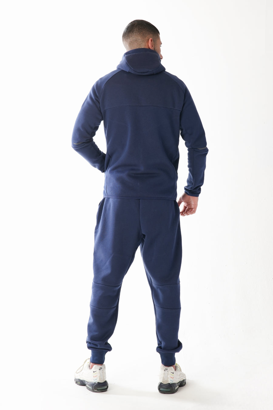 Man wearing a navy blue tracksuit on a white background