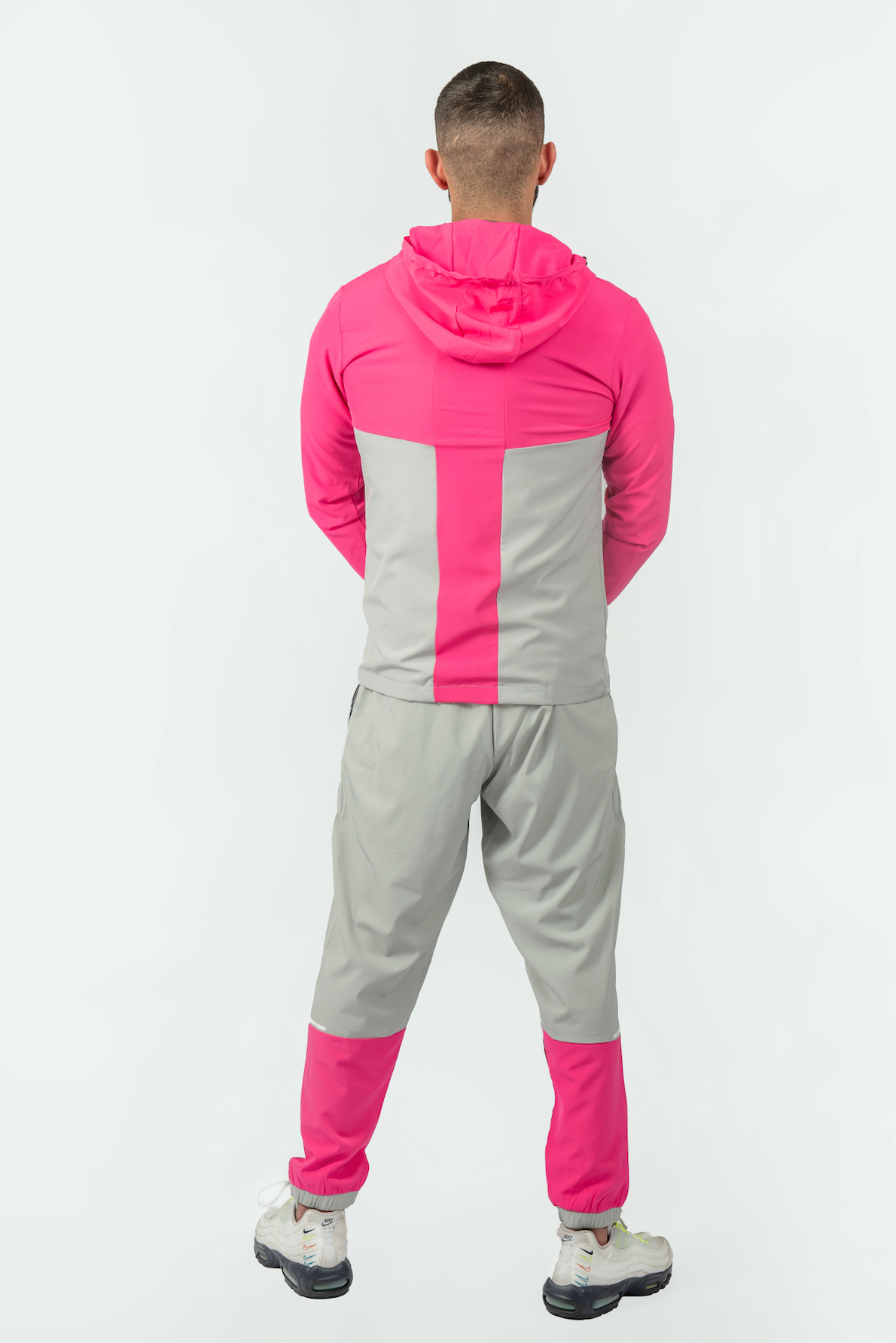 Person wearing a pink and gray tracksuit on a white background brand elegante