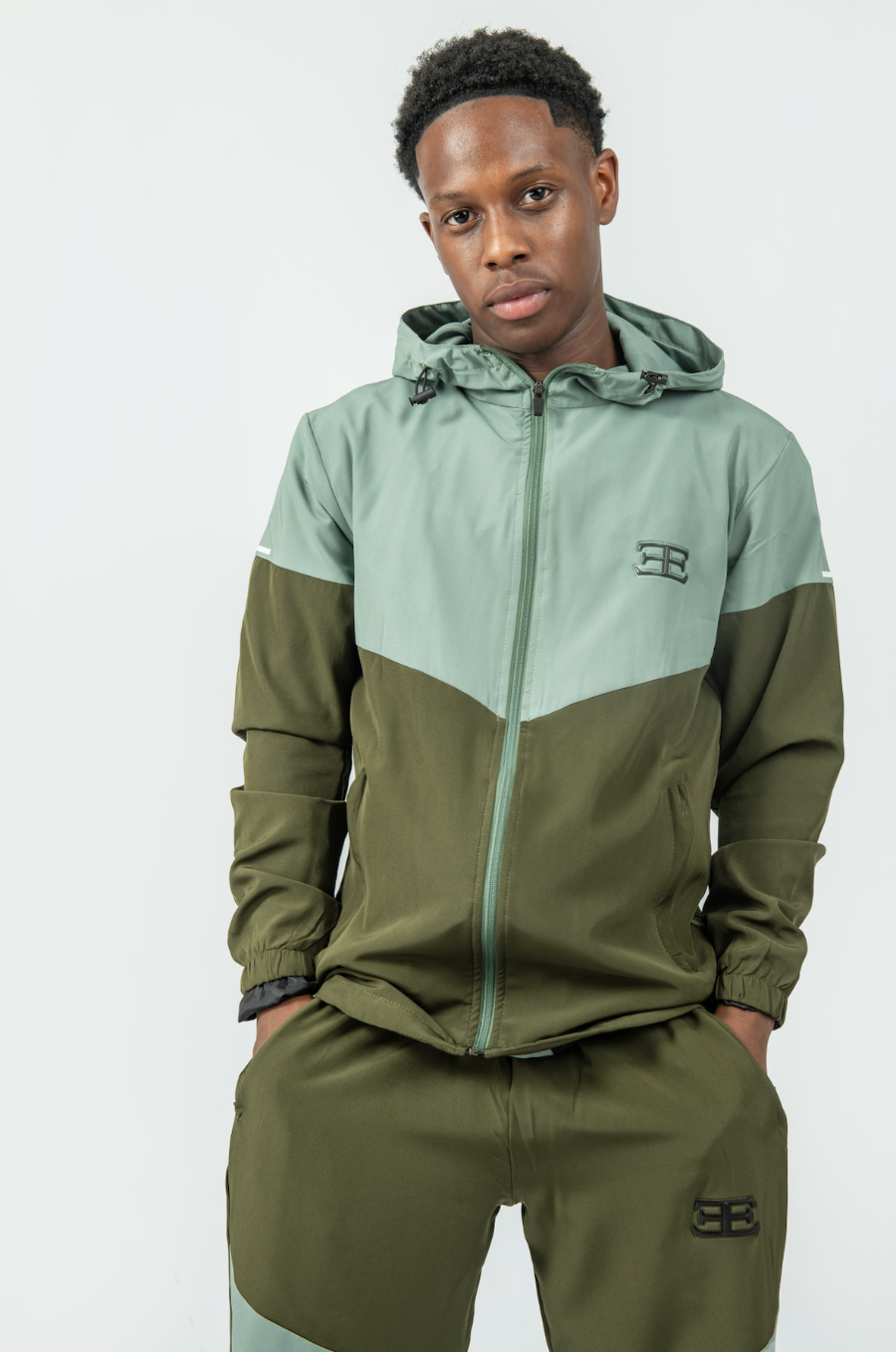 man wearing olive green Tracksuit joggers with hands in pockets, and tracksuit jacket set, mens sports tracksuit sets, activewear, gym wear clothing