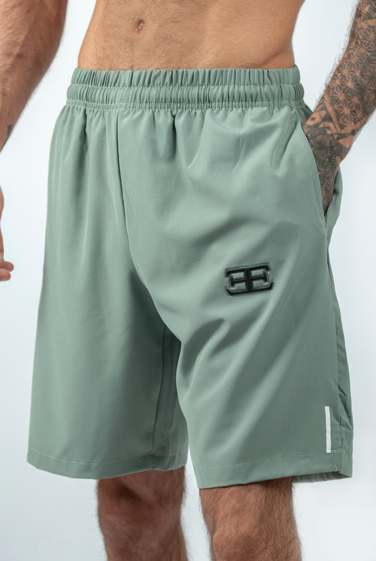 Green athletic shorts with a logo on a white background