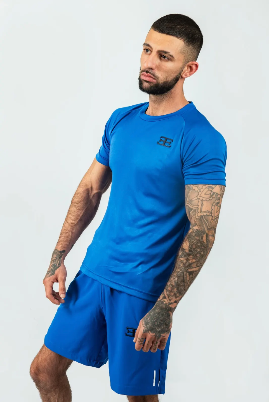 Man wearing a blue athletic outfit with a logo on a white background