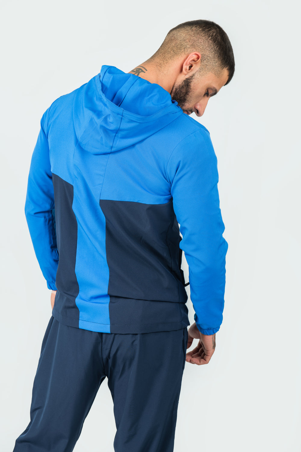 man wearing a blue and navy tracksuit on a white background