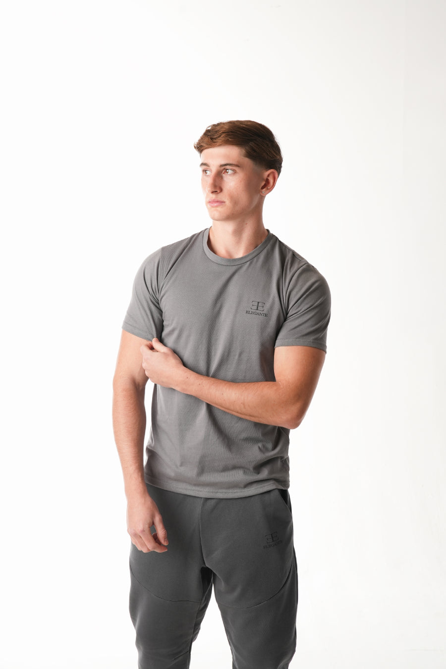 man wearing grey tshirt with elegante logo on chest on white background