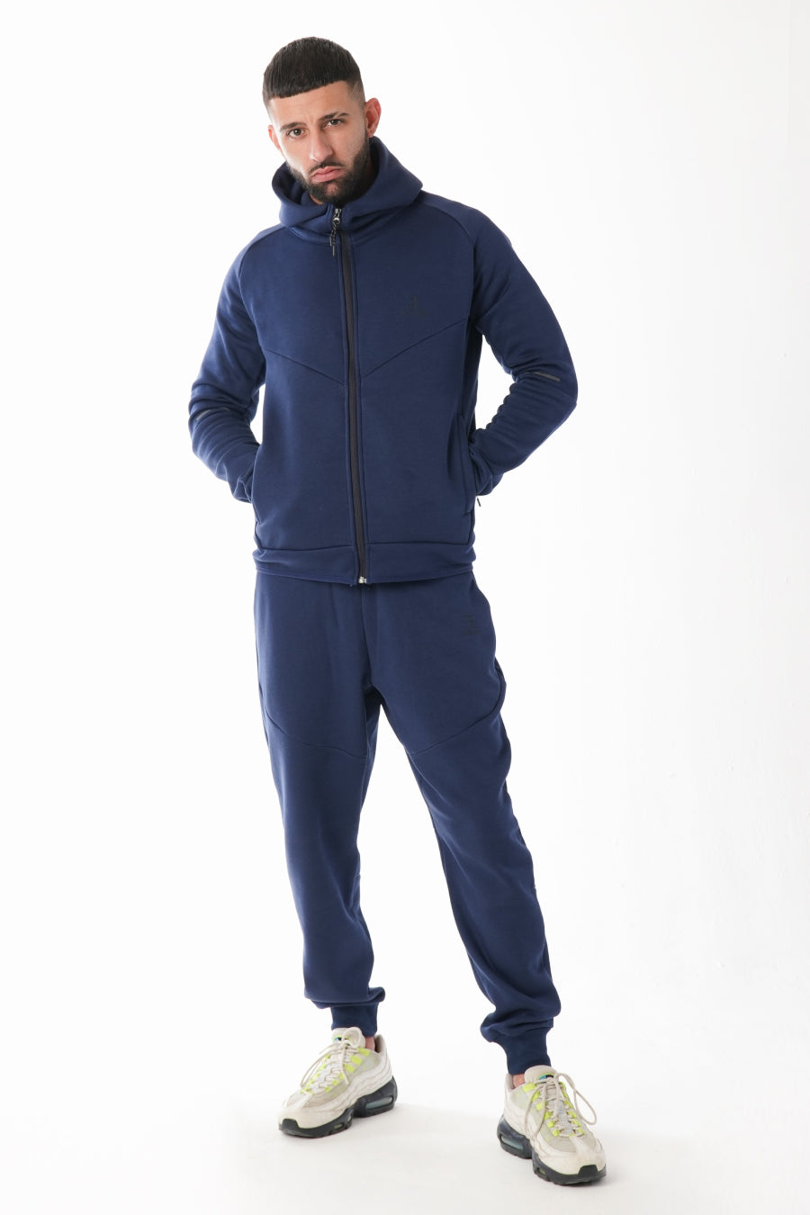 Man wearing a navy blue tracksuit on a white background