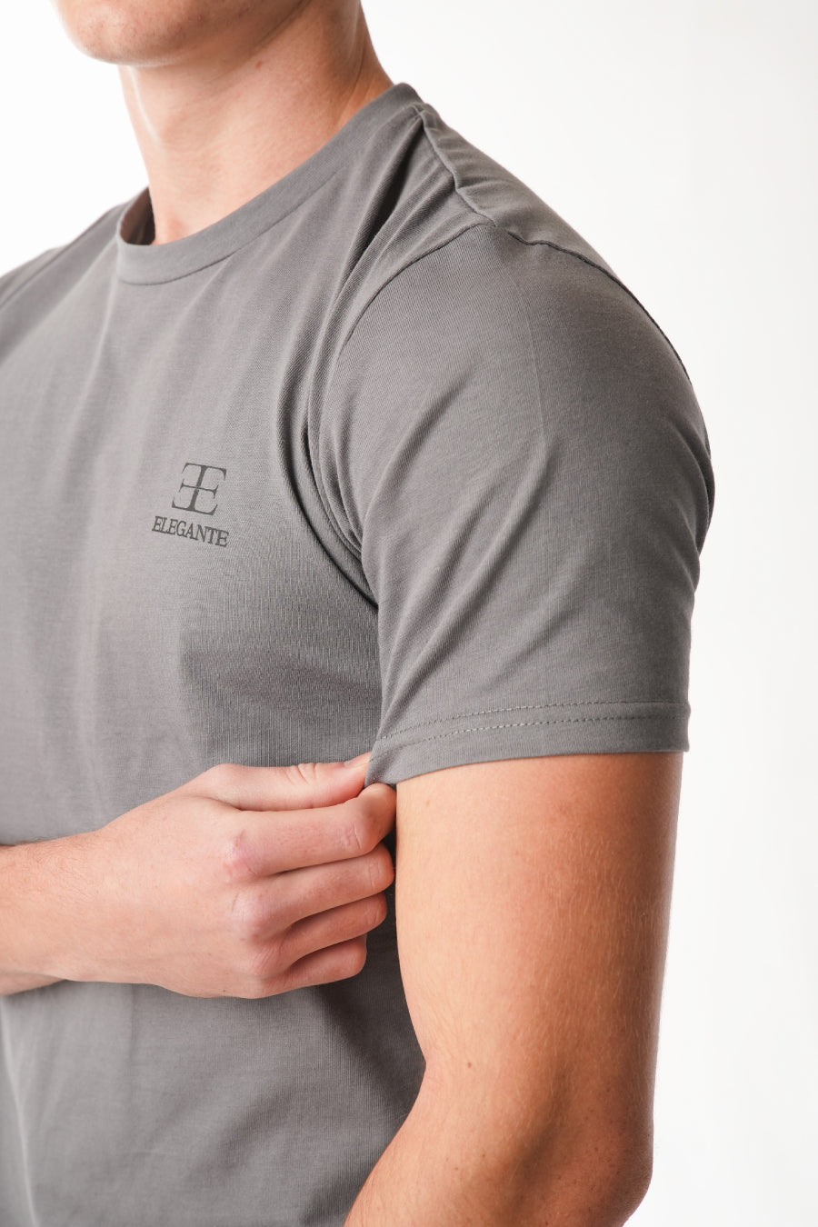 man wearing grey tshirt with elegante logo on chest on white background