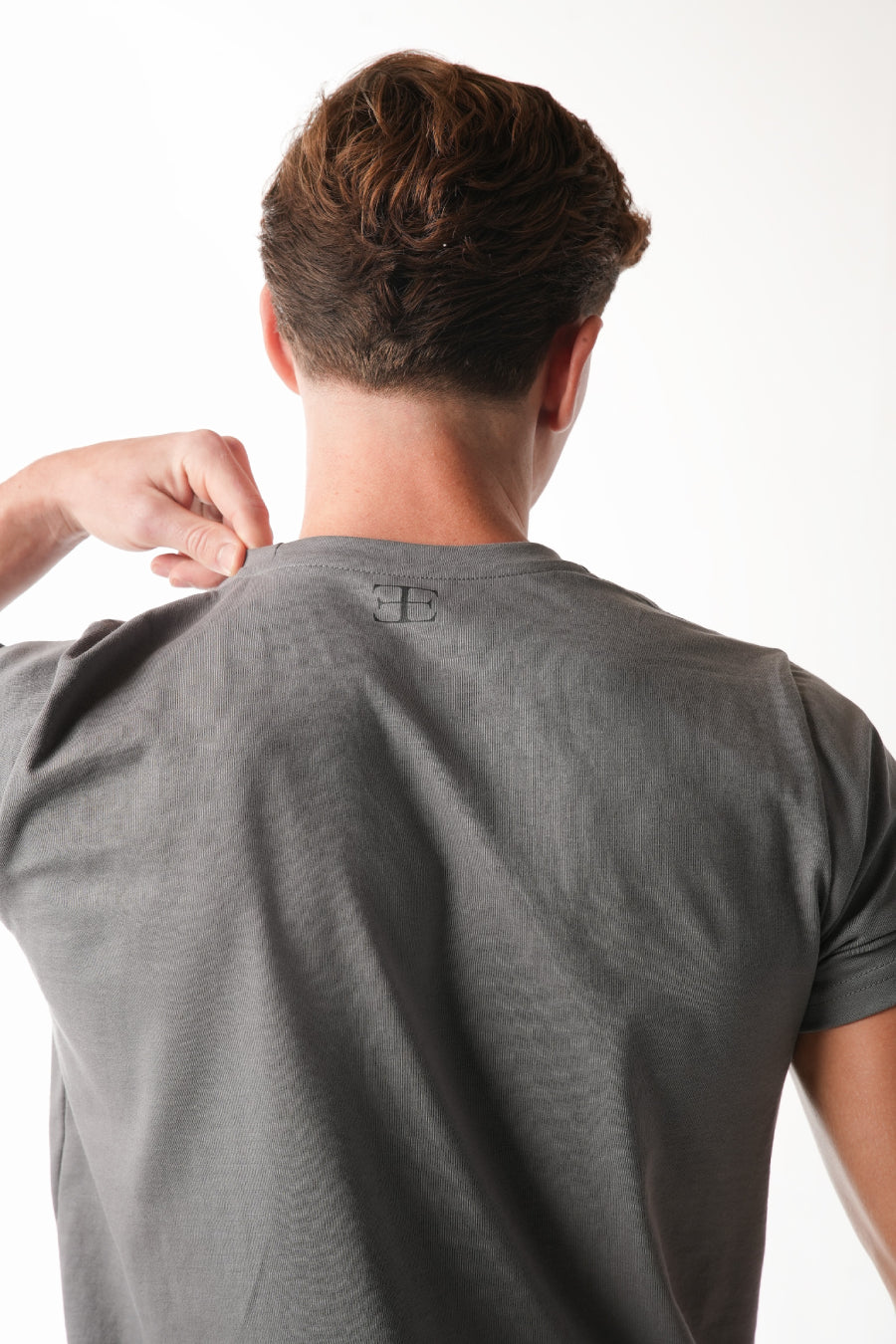 man wearing grey tshirt with elegante logo on chest on white background