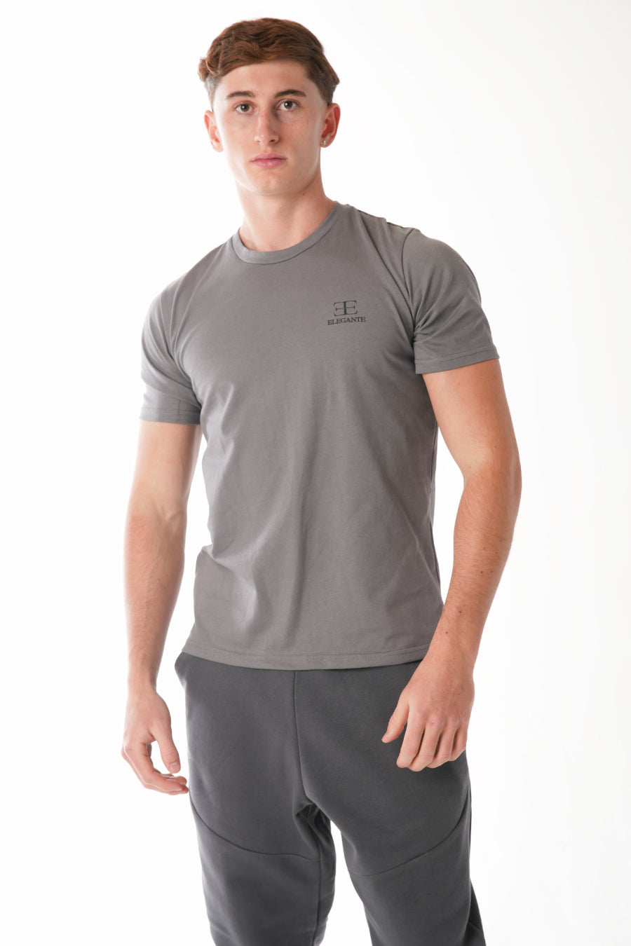 man wearing grey tshirt with elegante logo on chest on white background