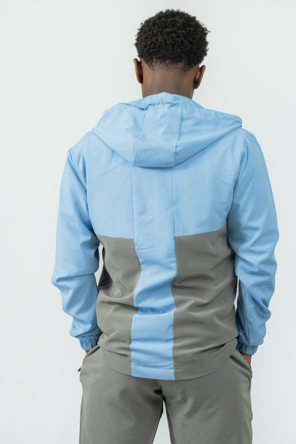 man wearing a blue and grey jacket with a white background